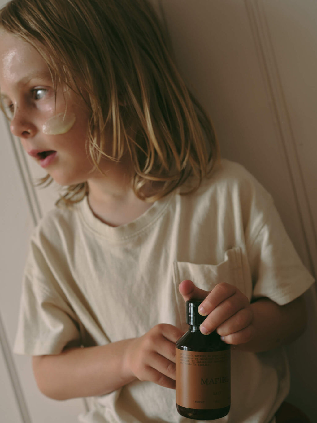 Enfant appliquant le lait hydratant MAPIEL sur son visage