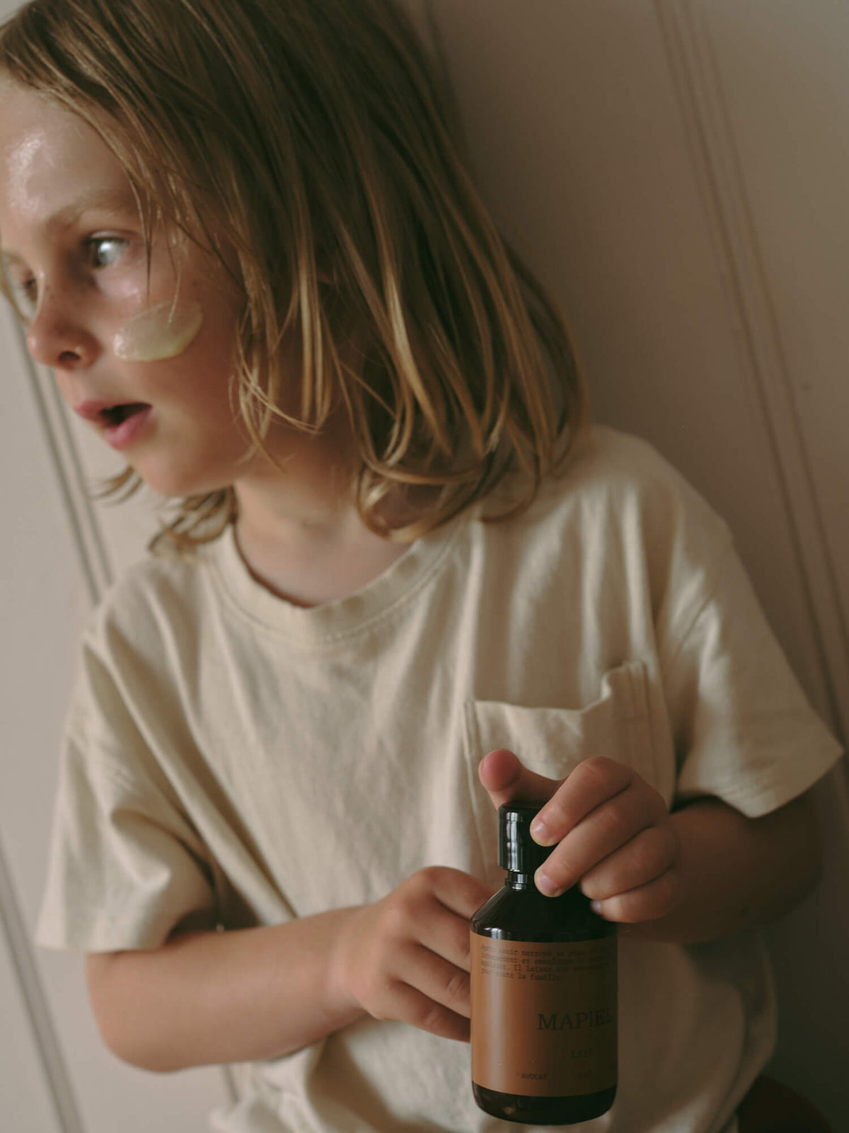 Enfant appliquant le lait hydratant MAPIEL sur son visage