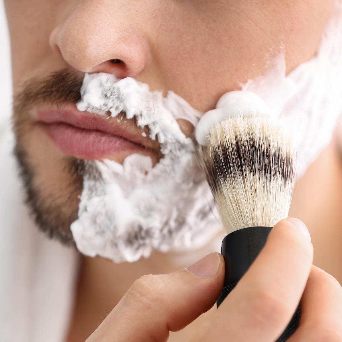 Application de la mousse à raser au blaireau