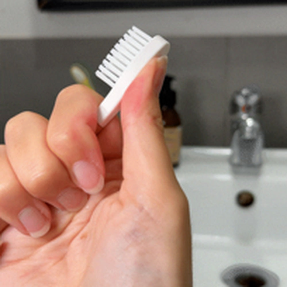 Tête de brosse à dents rechargeable tenue entre les doigts