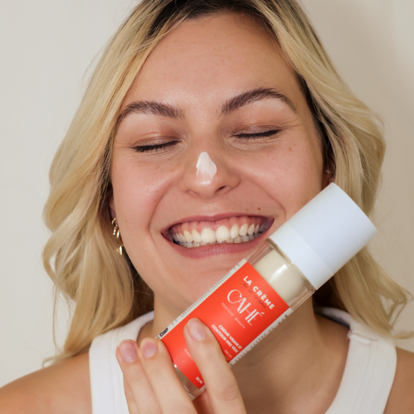 Femme appliquant la crème CAHÉ sur son visage